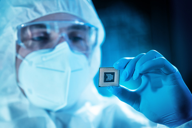 Professional scientist works in a modern scientific laboratory for the research and development of microelectronics and processors. Microprocessor manufacturing worker uses computer technology and equipment.