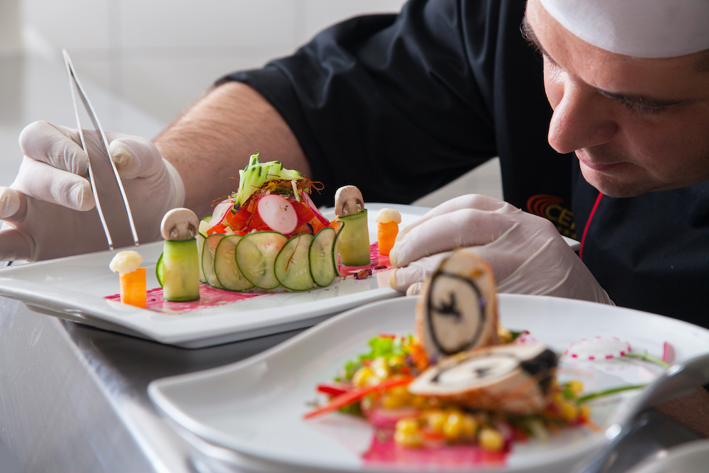 mature chef preparing a meal with various vegetables